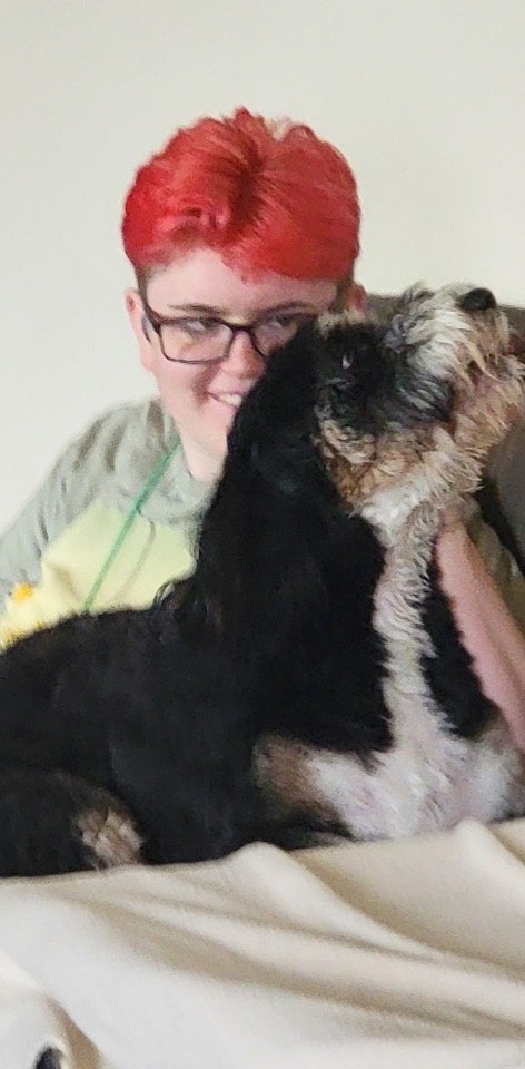Peko cuddling a boarding dog at Happy Tails